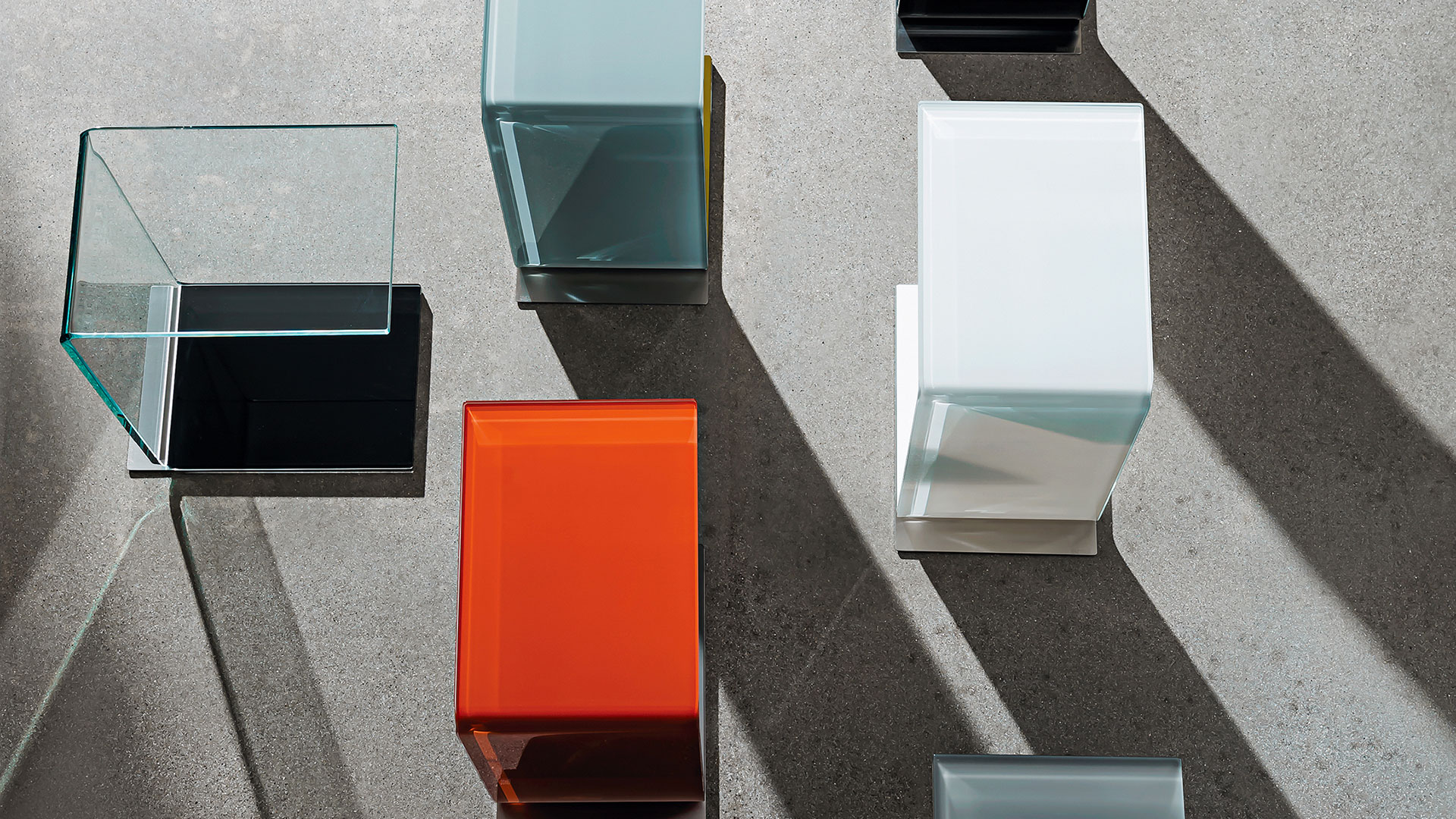 Quattro tavolini da divano in vetro curvo trasparente, colore ruggine, bianco e cemento