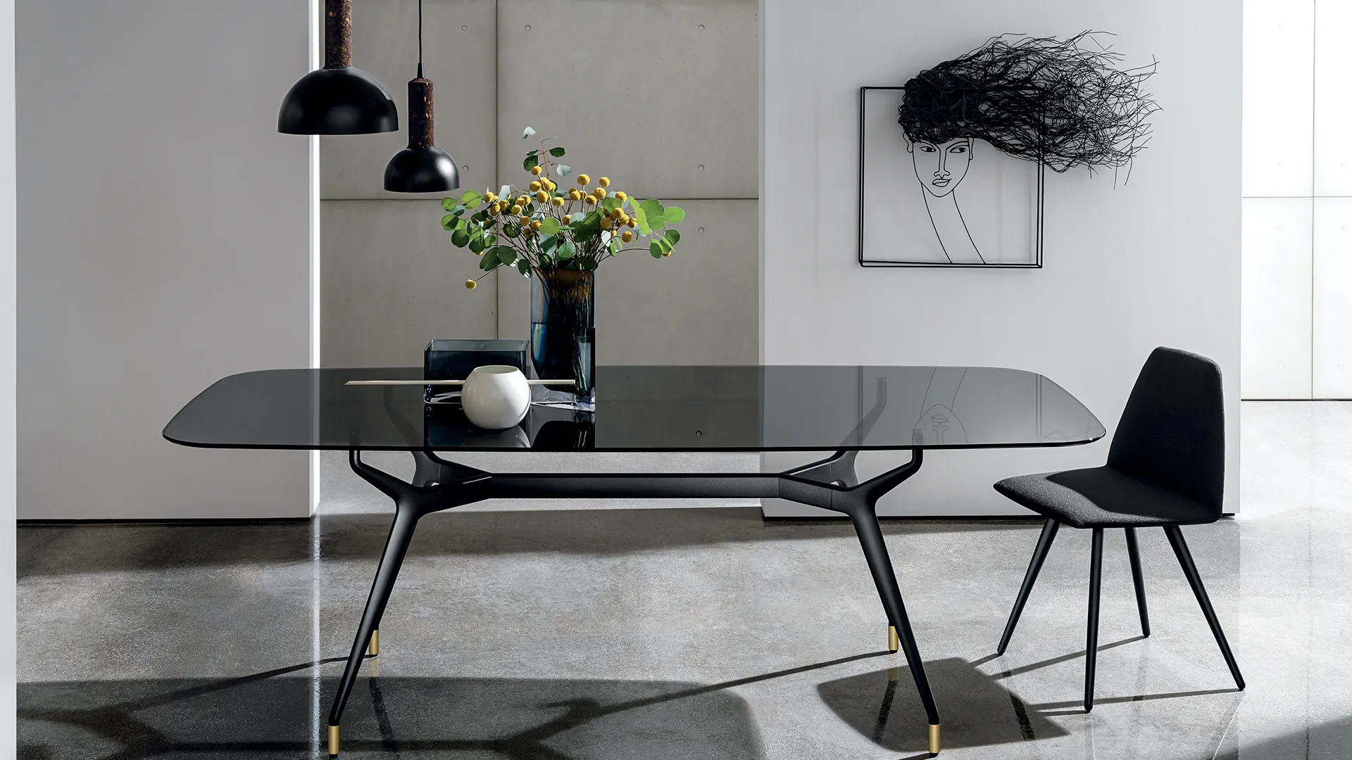 Tavolo di design dalla forma sagomata rettangolare con gambe e struttura in alluminio di colore nero e piano in vetro fumè
