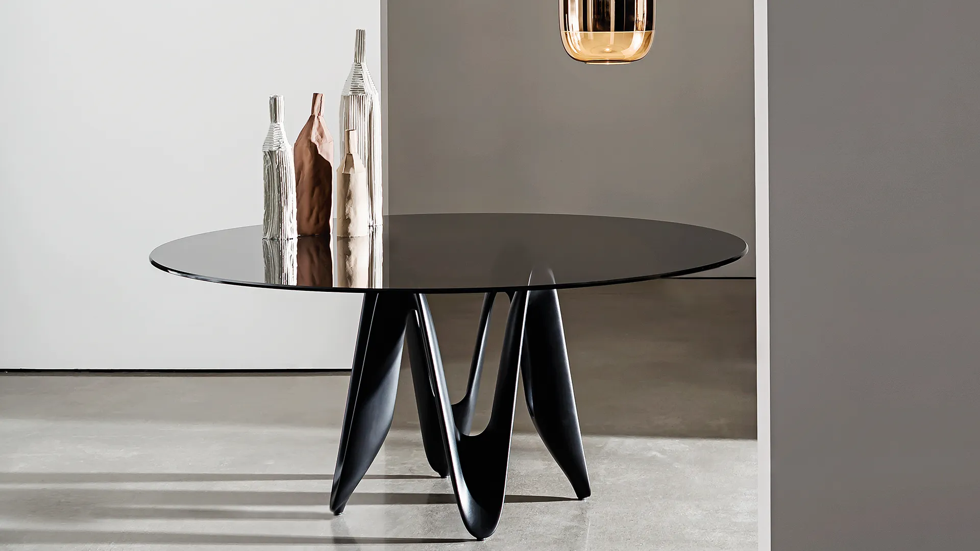 Tavolo rotondo con base composta in cristalplant colore nero e piano in vetro fumè