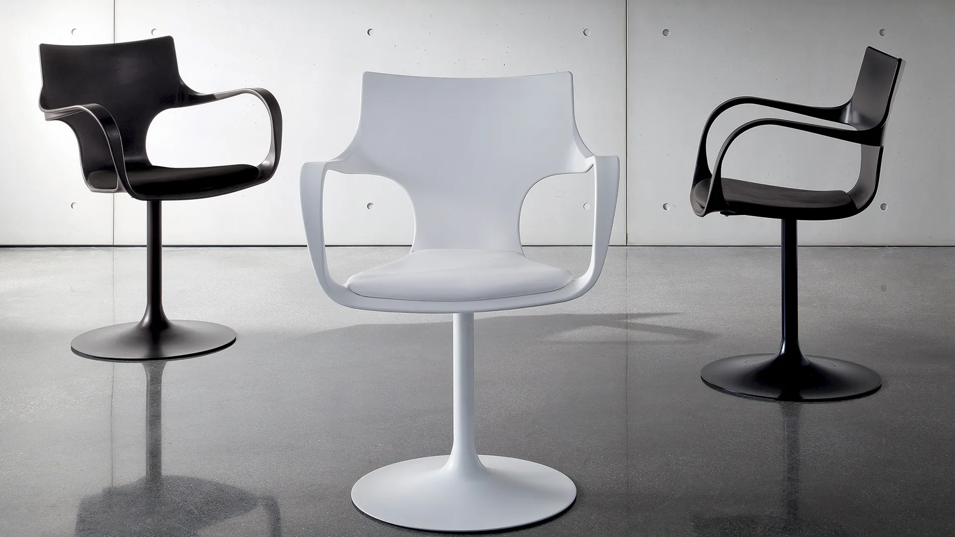 Sedia girevole con braccioli centrale, struttura in metallo laccato bianco e seduta rivestita in ecopelle bianco. Lateralmente sedie con struttura e s